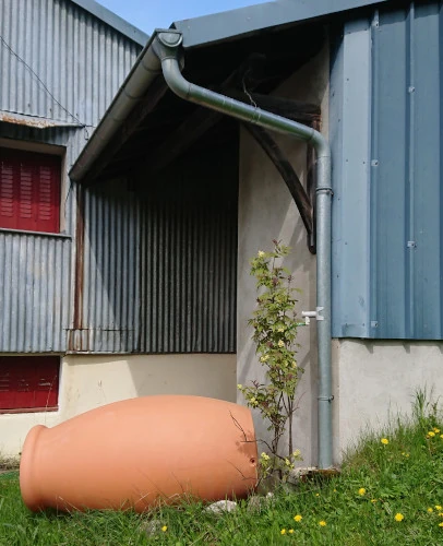 récupérateur d'eau de pluie couché et vidé pour résister au gel en montagne