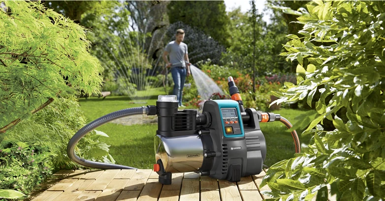 Un homme arrose son jardin en utilisant la pompe Gardena 6000